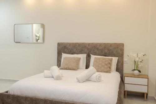 a bedroom with a white bed with pillows and a mirror at Elita suite in Eilat