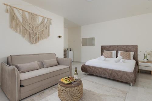 a living room with a bed and a couch at Elita suite in Eilat