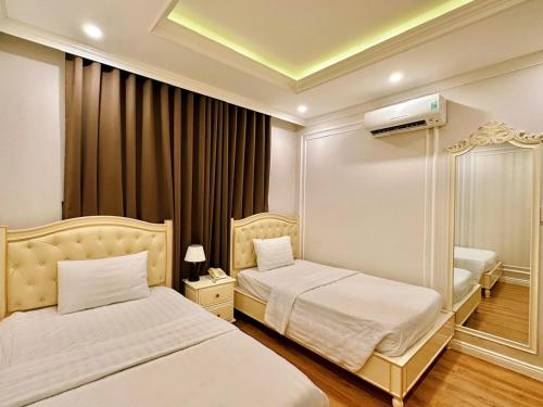 a hotel room with two beds and a mirror at Maya Hotel 2 in Con Dao