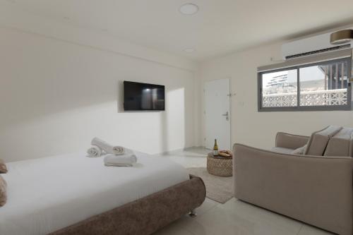 a bedroom with a bed and a couch and a television at Elita suite in Eilat