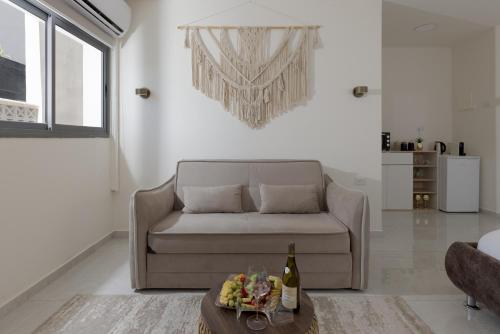 a living room with a couch and a table with a bottle of wine at Elita suite in Eilat