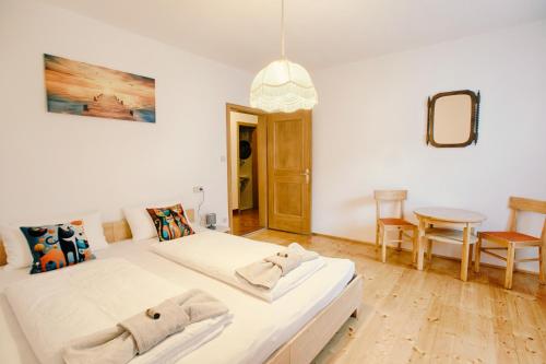 a white bedroom with two beds and a table at Apartment Carmen in Lasa