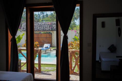 a room with a sliding glass door to a patio at Mambo Cabana in Pwani Mchangani