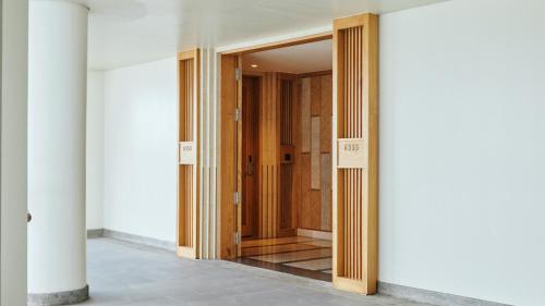 a hallway with a wooden door in a building at AYANA Segara Bali in Jimbaran