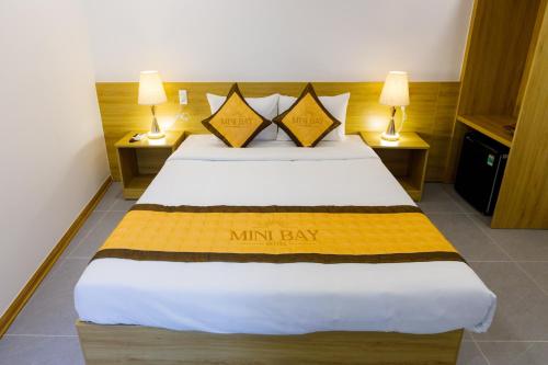 a large bed in a room with two lamps at Tuong Vy Mini Bay Hotel Mui Ne in Ấp Ngọc Hải