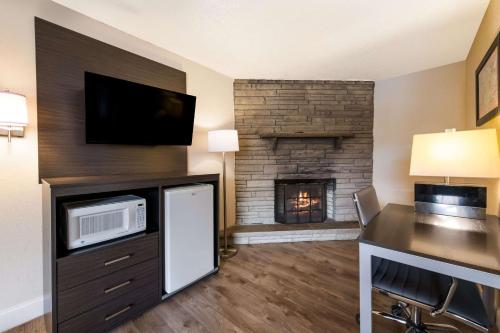 a living room with a fireplace with a microwave and a desk at Econo Lodge Inn & Suites on the River in Gatlinburg
