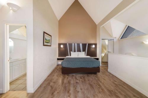 a bedroom with a bed and a bathroom at Econo Lodge Inn & Suites on the River in Gatlinburg