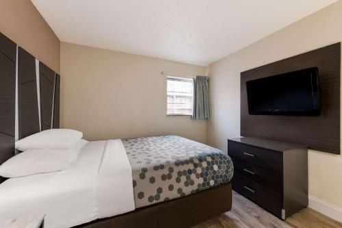 a hotel room with a bed and a flat screen tv at Econo Lodge Inn & Suites on the River in Gatlinburg