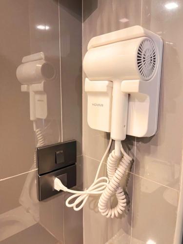 a phone is hanging on a wall in a bathroom at BB HOUSE Rangsit in Ban Talat Rangsit