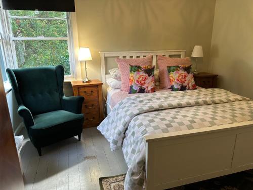 a bedroom with a bed and a blue chair at Bush Retreat Farm Stay 1BR Guest Suite in Alberton West