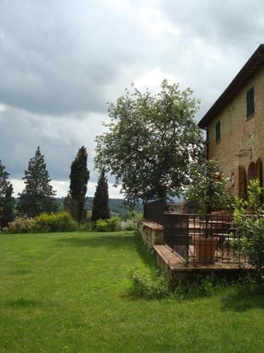 a building with a tree next to a green yard at Al Giardino Degli Etruschi in Chiusi