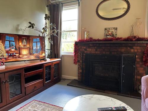 a living room with a fireplace and a mirror at Bush Retreat Farm Stay 1BR Guest Suite in Alberton West