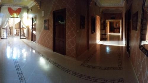 a hallway of a building with a tile floor and a door at Hotel Espace Tifawine in Tafraoute