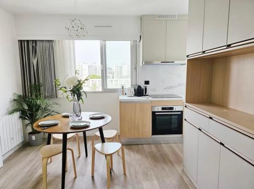une cuisine avec une table et des chaises dans une cuisine dans l'établissement Charme cosy apt au coeur de paris, à Paris