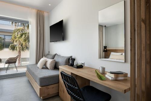 a living room with a couch and a desk with a mirror at Magda Hotel Club in Gouves