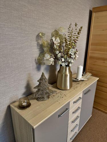 a table with a vase of flowers and a christmas tree on it at Penzion Solid Spa in Mladá Boleslav
