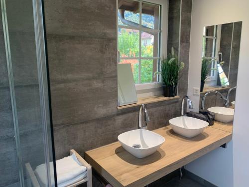 a bathroom with two sinks and a shower at Chalet l'Ermitage in Tavannes