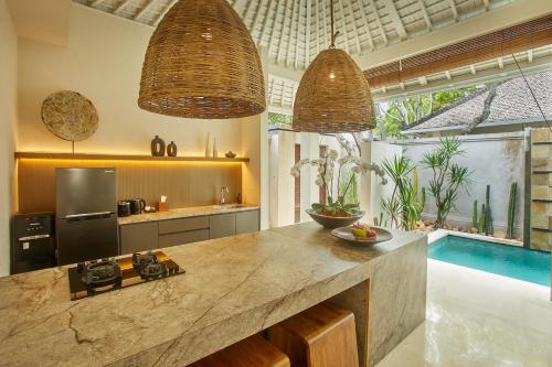 a kitchen with a counter top and a pool at Ahimsa Beach in Jimbaran