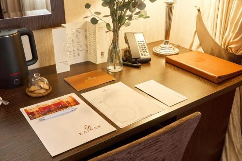 a desk with a phone and a book on it at Kainar Hotel in Shymkent