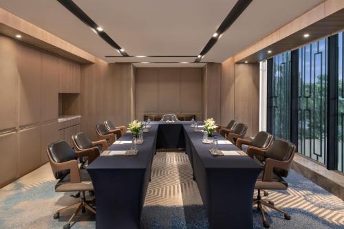 a conference room with a long table and chairs at Navi Mumbai Marriott in Navi Mumbai