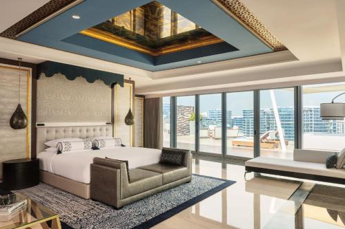 a bedroom with a bed and a chair and a couch at Marriott Marquis Dubai Creek in Dubai