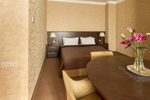 a hotel room with a bed and a table at Kainar Hotel in Shymkent