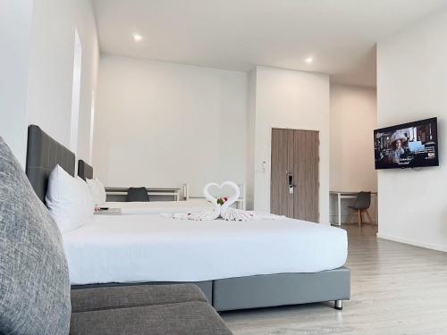 a bedroom with a large white bed and a tv at GRAND PA Hotel&Resort Lamphun Chiang Mai in Lamphun