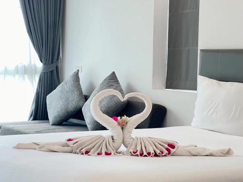 two swans made out of towels on a bed at GRAND PA Hotel&Resort Lamphun Chiang Mai in Lamphun