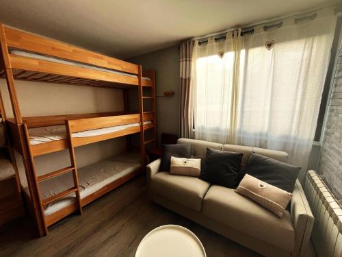 Cette petite chambre comprend un canapé et des lits superposés. dans l'établissement l'Armazan - studio pieds de piste Plat d'Adet, à Saint-Lary-Soulan
