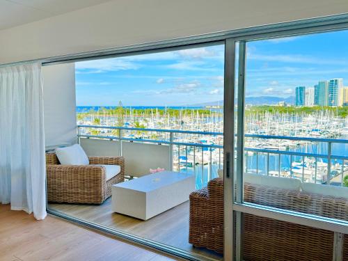 a living room with a balcony with a view of a harbor at Panoramic Oceanview Resort - Full Kitchen in Each Unit, 2 Swimming Pools, Onsite Restaurants, Fireworks Every Friday in Honolulu