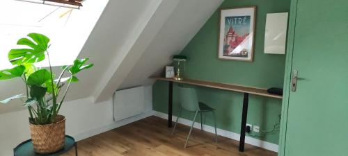 a room with a desk and a green wall at CITY HÔTE appartement centre ville au calme vue sur le château in Vitré