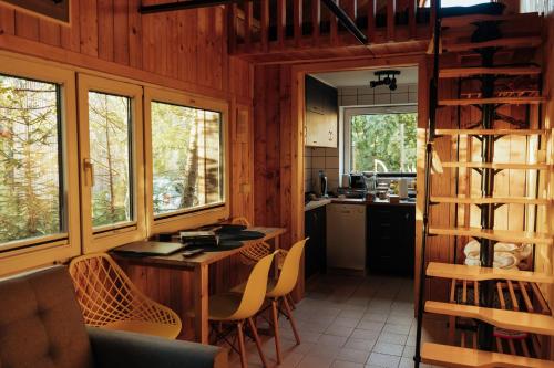 a kitchen and dining room with a table and chairs at Domki na Widoku in Lubomierz