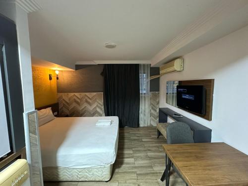 Habitación pequeña con cama y mesa en BetaS GuestHouse, en Antalya