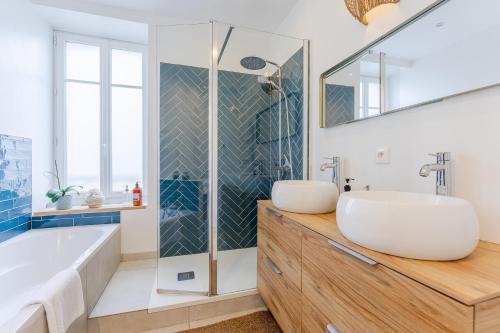 a bathroom with a tub and a sink at Maison Athlos - Quartier calme au coeur de Nantes in Nantes