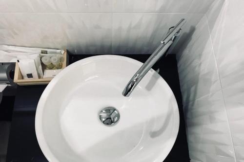 a bathroom with a white sink with a metal handle at Snooze Inn Phuket - Free Shuttle to Bang Rong Pier in Ban Pa Khlok