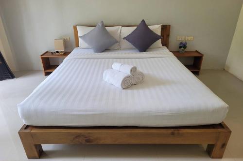 a bedroom with a bed with towels on it at Snooze Inn Phuket - Free Shuttle to Bang Rong Pier in Ban Pa Khlok