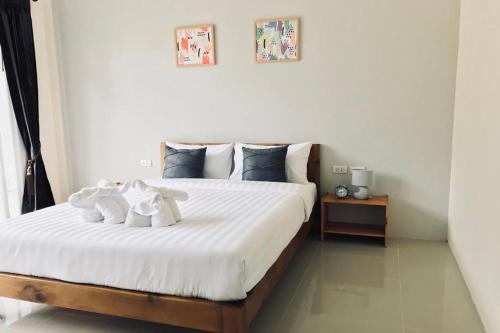 a bedroom with a large bed with white sheets at Snooze Inn Phuket - Free Shuttle to Bang Rong Pier in Ban Pa Khlok