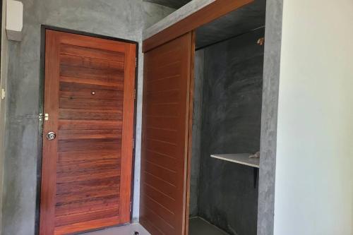a wooden door in the corner of a room at Snooze Inn Phuket - Free Shuttle to Bang Rong Pier in Ban Pa Khlok