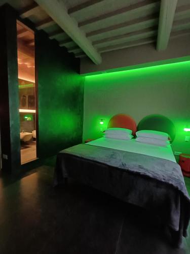 a green room with a bed with a green wall at Vistaperdue in Peccioli
