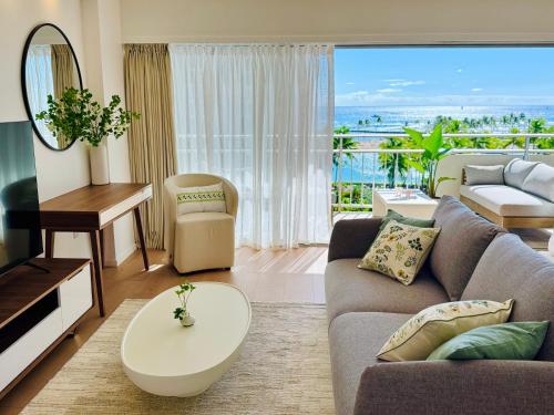 a living room with a couch and a table and a television at Panoramic Oceanview Resort - Full Kitchen in Each Unit, 2 Swimming Pools, Onsite Restaurants, Fireworks Every Friday in Honolulu