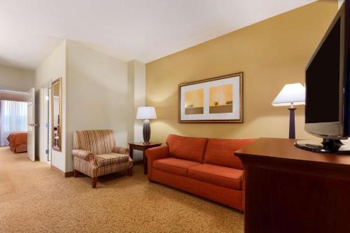 a hotel room with a couch and a tv at Country Inn & Suites by Radisson, Texarkana, TX in Texarkana - Texas
