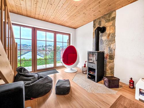 sala de estar con chimenea y silla roja en Apartment Robin, en Erbach