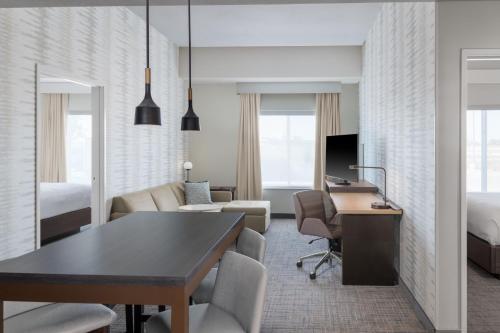 a hotel room with a desk and a bedroom at Residence Inn by Marriott Oklahoma City Norman in Norman