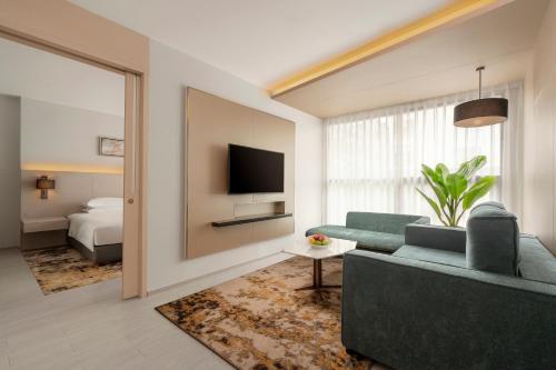 a living room with a couch and a television at Hyatt Place Bangkok Sukhumvit 1 in Bangkok