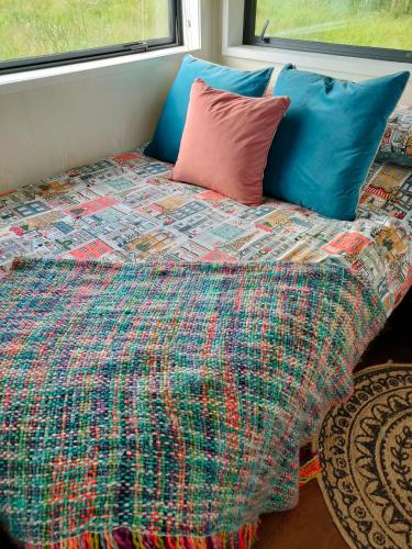 Una cama con una manta colorida y almohadas. en Penhill Hideaway, en Maxwell