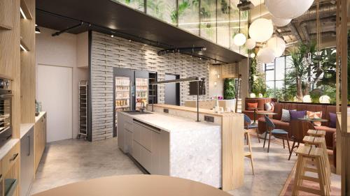 a kitchen with a counter and some tables and chairs at Cocoon Theresienwiese in Munich