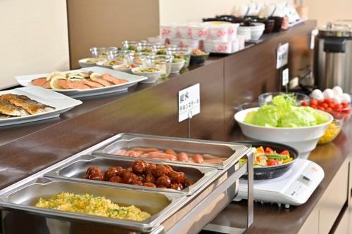 a buffet line with many different types of food at Saijo Urban Hotel in Saijo