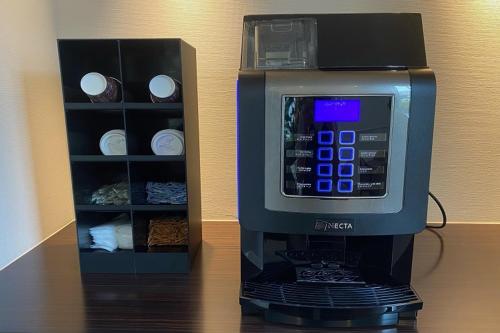a starbucks espresso machine sitting next to a spice rack at Saijo Urban Hotel in Saijo