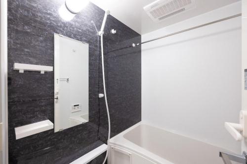 a bathroom with a shower and a tub and a sink at PREAS Nakano Arai in Tokyo