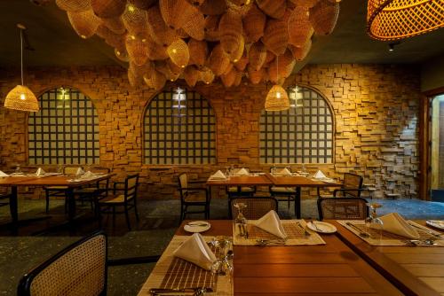 a dining room with tables and chairs and a chandelier at Majentra Ella in Ella